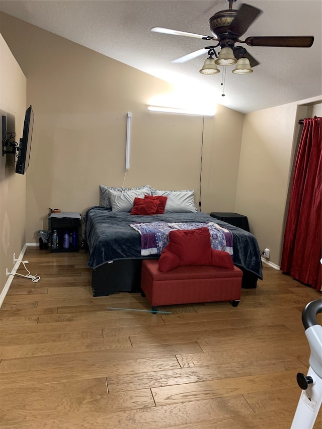 bedroom featuring hardwood / wood-style floors, a textured ceiling, and ceiling fan