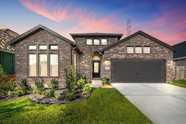 front facade featuring a garage and a lawn