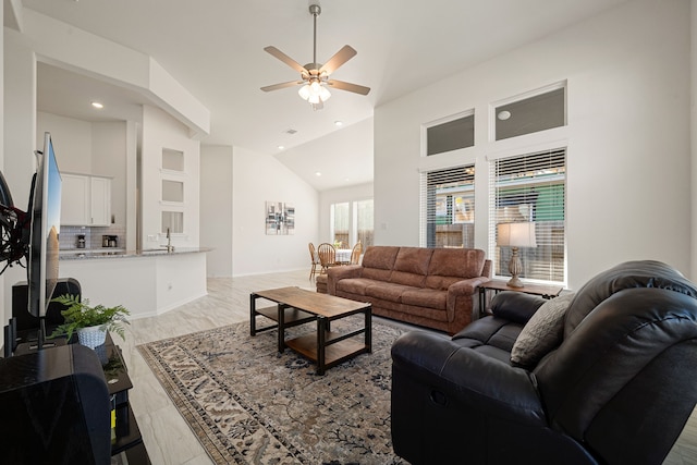 living room featuring light wood-type flooring, high vaulted ceiling, and ceiling fan