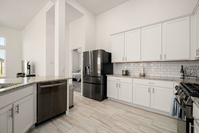 kitchen with light stone counters, white cabinets, appliances with stainless steel finishes, and tasteful backsplash