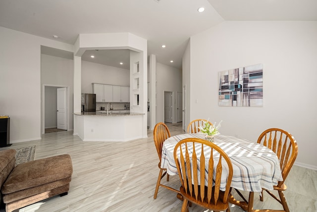 dining area with high vaulted ceiling and sink