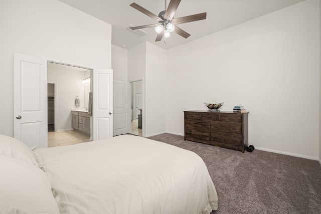 carpeted bedroom featuring ceiling fan, a high ceiling, and ensuite bath