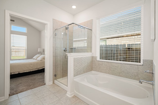 bathroom featuring vaulted ceiling, separate shower and tub, tile patterned flooring, and a healthy amount of sunlight