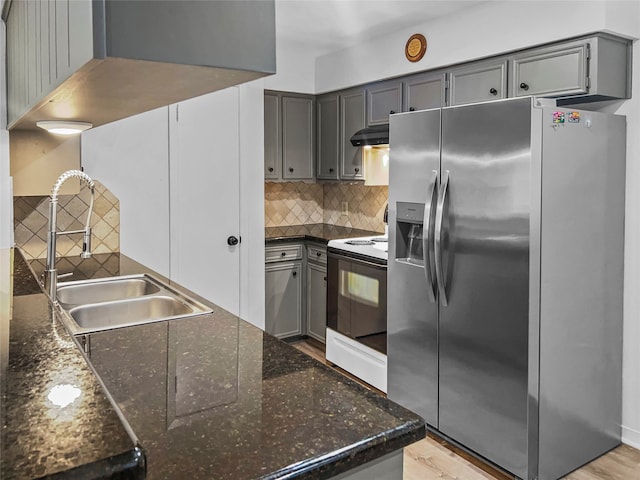 kitchen featuring sink, light hardwood / wood-style flooring, electric range, and stainless steel fridge