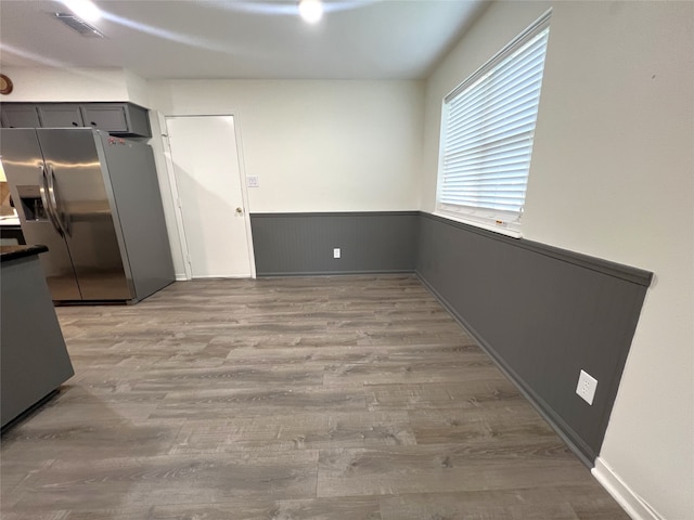 kitchen with light hardwood / wood-style floors, gray cabinets, and stainless steel fridge