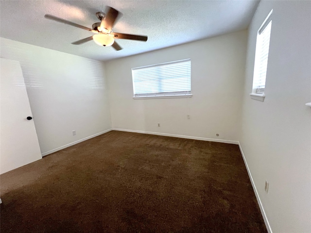 carpeted spare room featuring a textured ceiling and ceiling fan