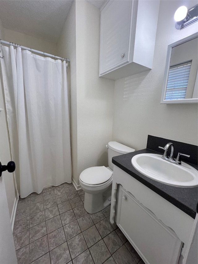 bathroom featuring a textured ceiling, walk in shower, toilet, vanity, and tile patterned floors