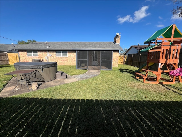 view of yard featuring a hot tub, a patio, and a playground