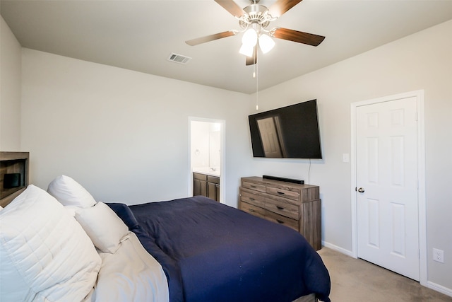 bedroom featuring ceiling fan, connected bathroom, and light colored carpet