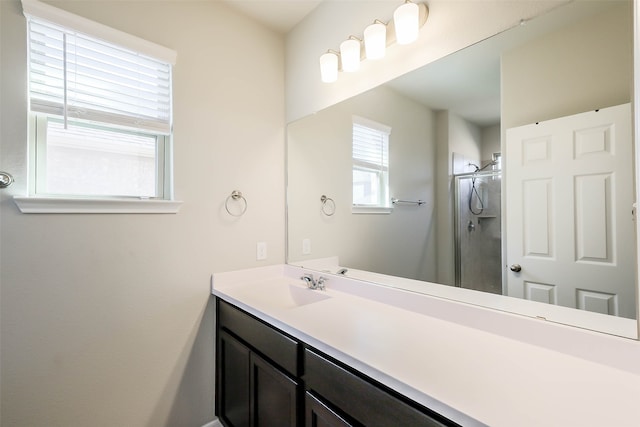 bathroom with a shower with shower door and vanity