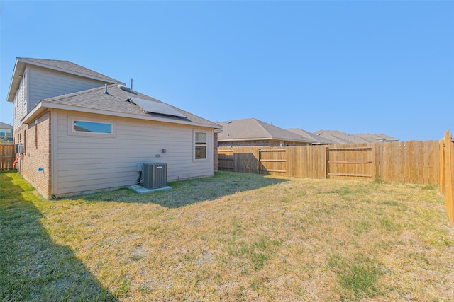 rear view of property with a yard and central AC