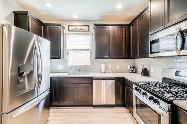 kitchen featuring appliances with stainless steel finishes, dark brown cabinetry, sink, and backsplash