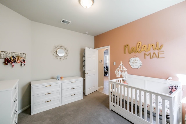 bedroom with a nursery area and carpet floors