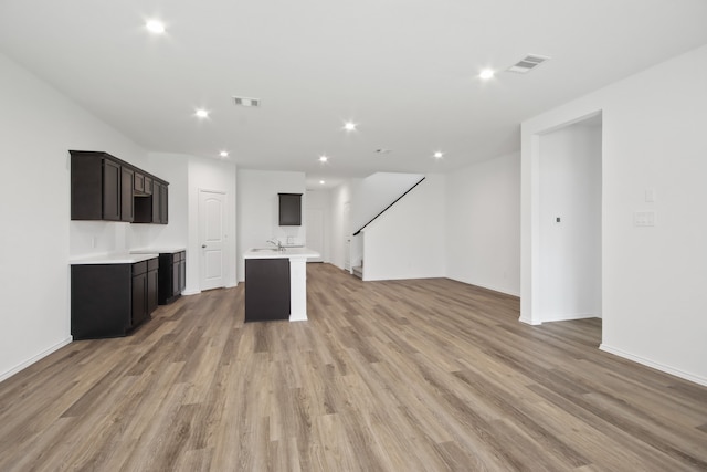 unfurnished living room featuring wood-type flooring and sink