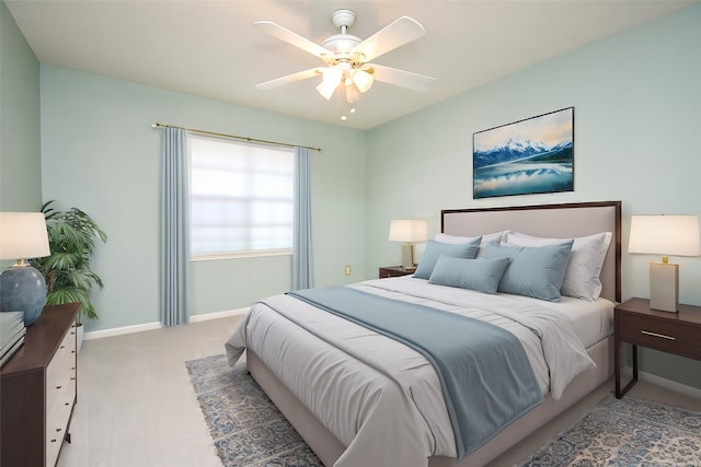 carpeted bedroom with ceiling fan and baseboards