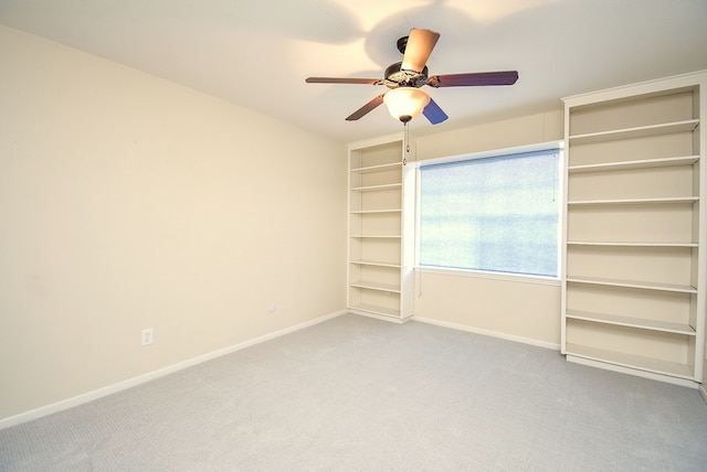 unfurnished bedroom with light carpet, baseboards, and a ceiling fan