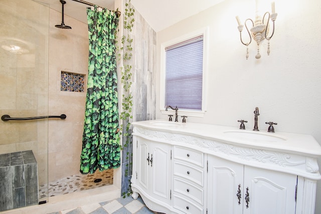 bathroom featuring tiled shower, a sink, and double vanity