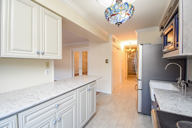 kitchen featuring a chandelier, crown molding, white cabinetry, and decorative light fixtures