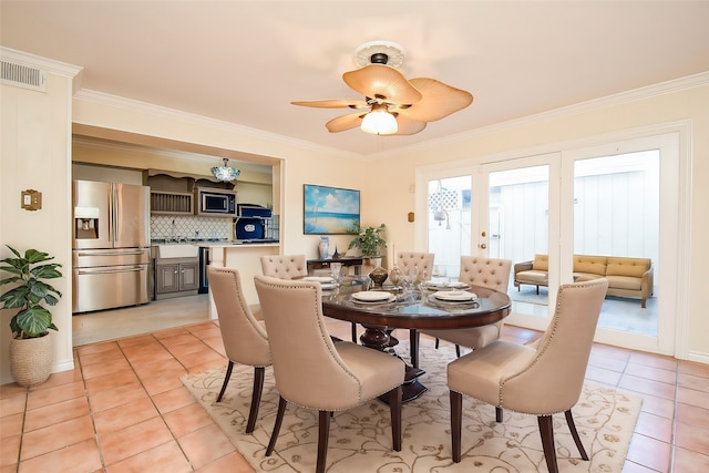 tiled dining space featuring crown molding, ceiling fan, and sink