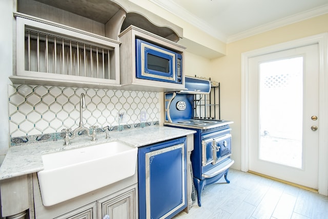 kitchen with blue cabinets, stainless steel microwave, ornamental molding, and a wealth of natural light