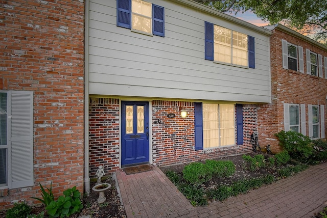 exterior entry at dusk with brick siding