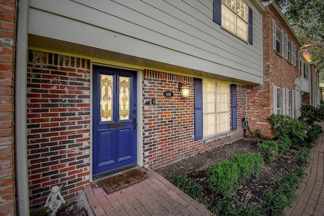 view of exterior entry featuring brick siding