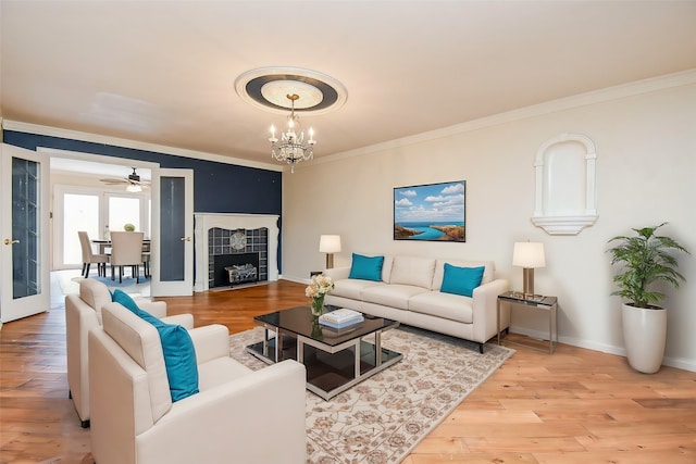 living room with light wood-type flooring, crown molding, and a fireplace