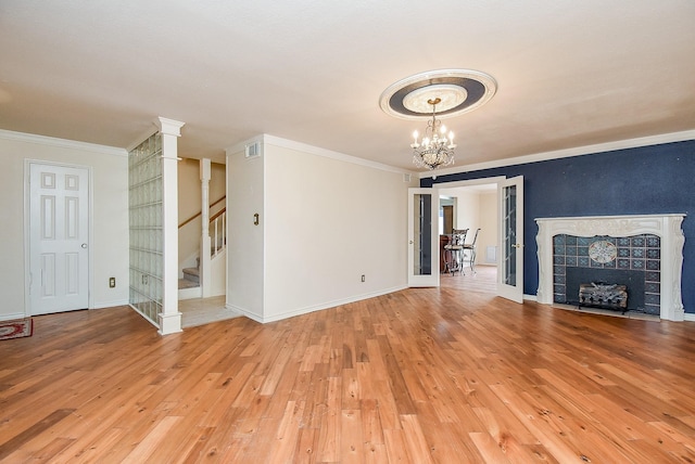 unfurnished living room featuring light hardwood / wood-style floors, a chandelier, and ornamental molding