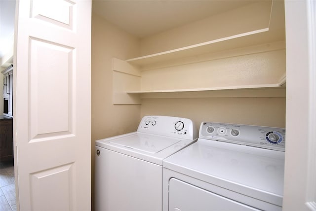 clothes washing area with wood-type flooring and washer and dryer