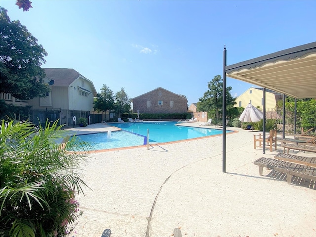 community pool featuring fence and a patio