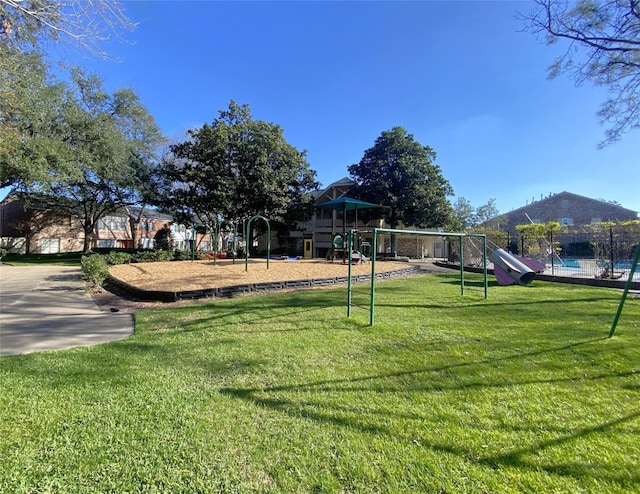 view of yard featuring playground community and fence