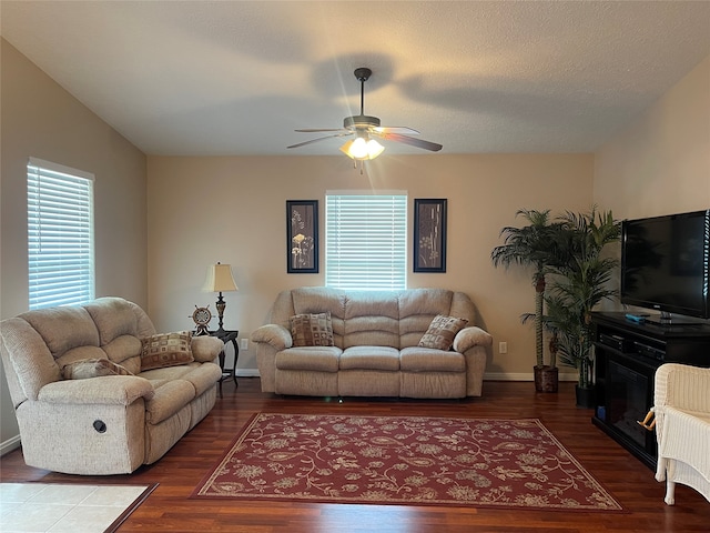 living room featuring wood-type flooring, a textured ceiling, and ceiling fan