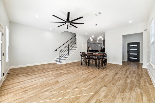 interior space with a healthy amount of sunlight, light hardwood / wood-style floors, and ceiling fan with notable chandelier