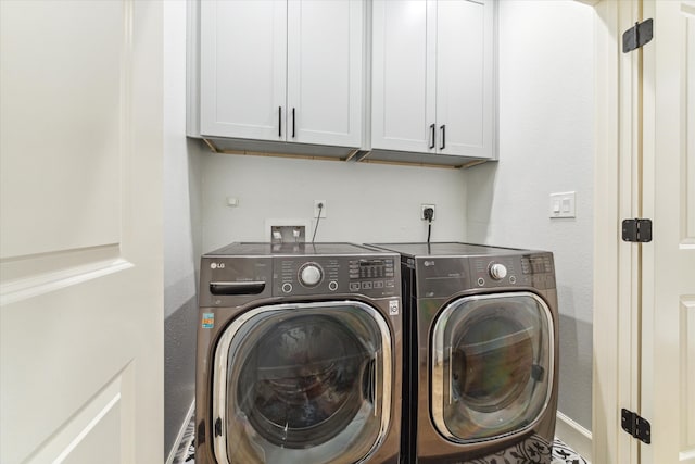 laundry room featuring cabinets and washing machine and dryer