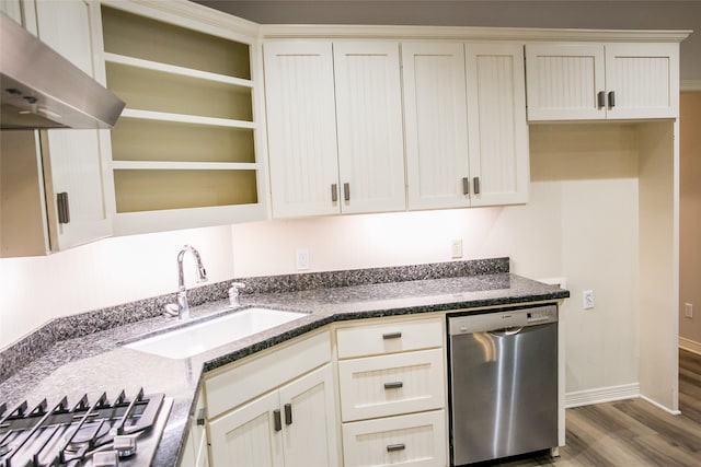 kitchen with sink, dark stone countertops, extractor fan, appliances with stainless steel finishes, and hardwood / wood-style flooring