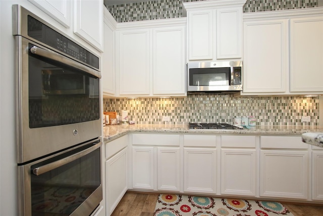 kitchen with white cabinetry, light hardwood / wood-style flooring, and stainless steel appliances