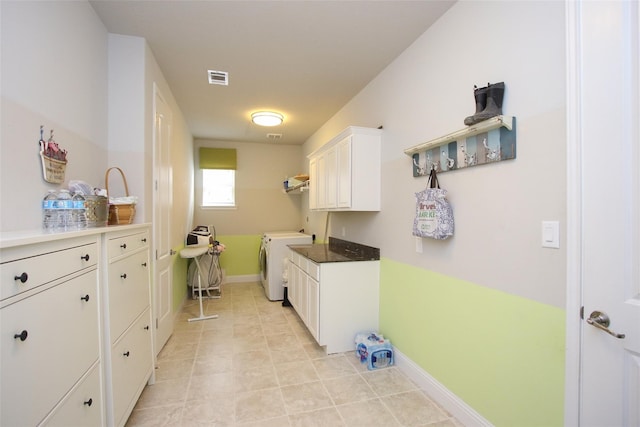 laundry area with cabinets, washing machine and dryer, and light tile patterned floors