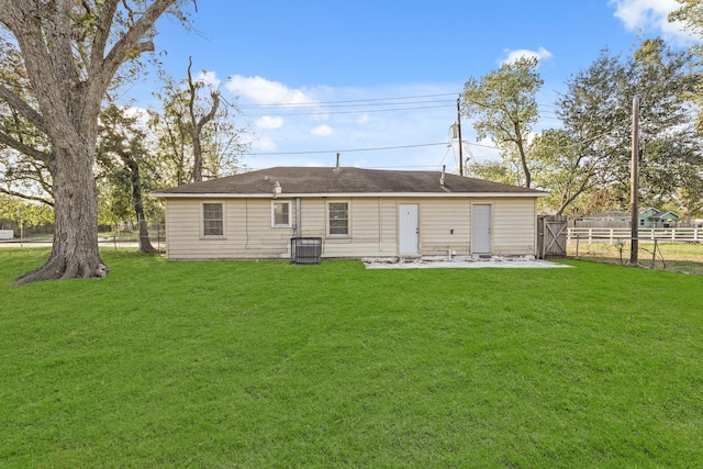 back of house with a lawn and central air condition unit