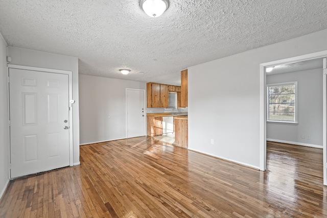 unfurnished living room featuring light hardwood / wood-style floors and a textured ceiling