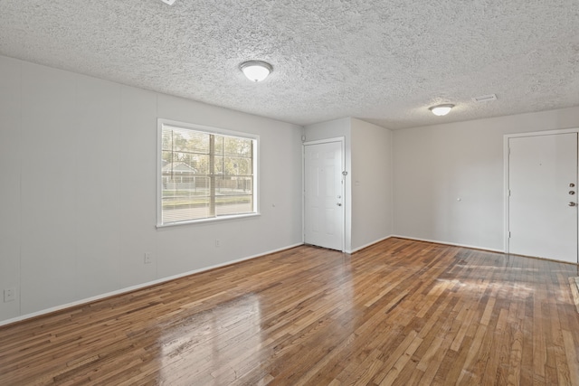 empty room featuring hardwood / wood-style floors and a textured ceiling