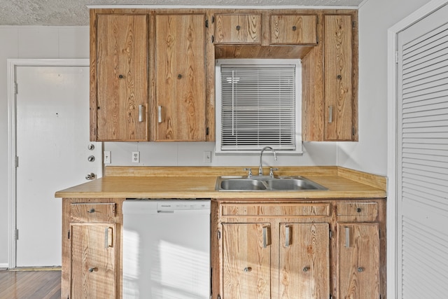 kitchen with a textured ceiling, dishwasher, and sink