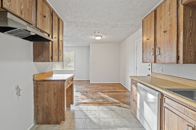 kitchen with a textured ceiling, light hardwood / wood-style floors, white dishwasher, and sink