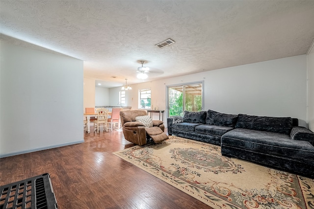 living room with ceiling fan, hardwood / wood-style flooring, and a textured ceiling