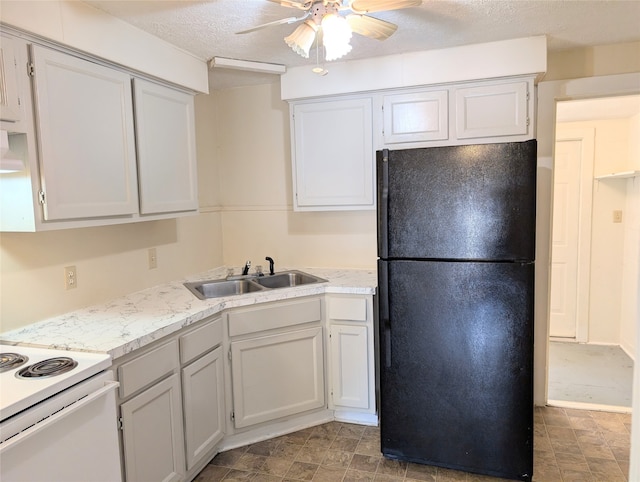 kitchen featuring sink, black refrigerator, a textured ceiling, and ceiling fan