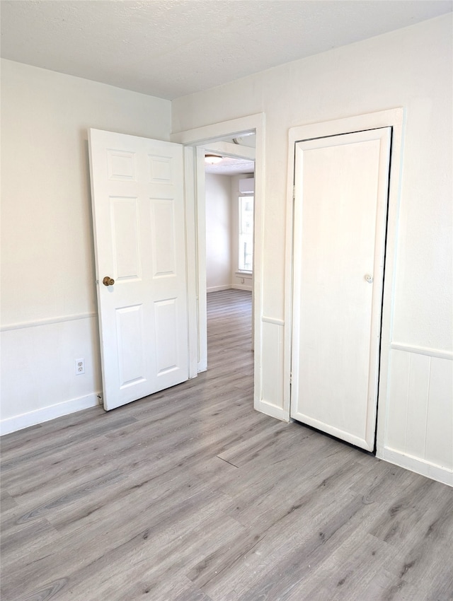 empty room featuring a textured ceiling and light wood-type flooring