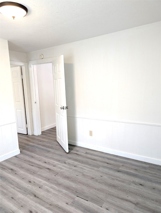 unfurnished room featuring a textured ceiling and dark hardwood / wood-style floors