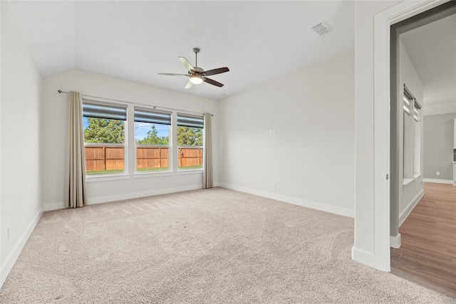 empty room with vaulted ceiling, light carpet, and ceiling fan