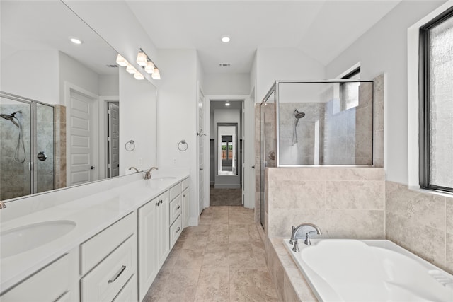 bathroom featuring vanity, vaulted ceiling, shower with separate bathtub, and tile patterned floors