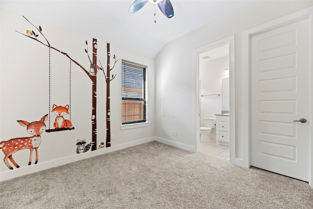 unfurnished bedroom with vaulted ceiling, ceiling fan, ensuite bathroom, and light colored carpet