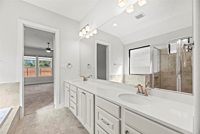 bathroom with tile patterned floors, independent shower and bath, vaulted ceiling, vanity, and ceiling fan